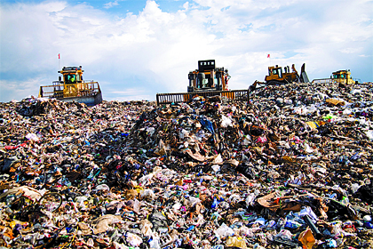 Bulldozers compact trash at Cedar Hills Regional Landfill in Maple Valley. Families can slow the filling of the landfill and prevent carbon emissions by recycling more.