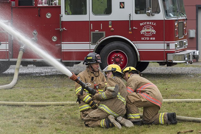 An instructor assists two WANIC students with a hands-on exercise in the program's fire and EMS course.