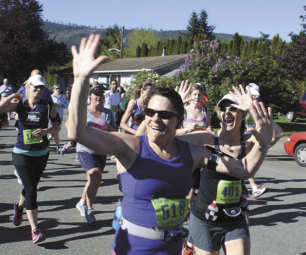 Participants Jo Ann Tracy of Pullman and Geri Pingul of Seattle wave to family members at the start of the half-marathon at the May 4 Cinco de Mayor fun run in Snoqualmie.