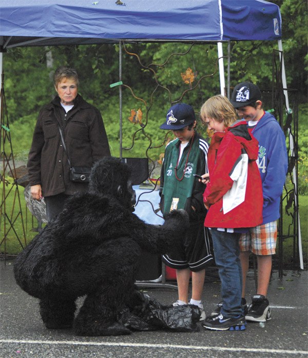 A Trash Ape performance artist meets locals during Fall City Days. Look for these playful creatures on the downtown streets this Saturday.
