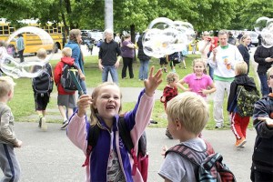 First grader Olivia O’Neill plays in the breeze of bubbles as Opstad Elementary School wraps up classes Wednesday