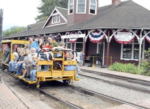 Families pile on for a speeder car ride down the tracks.