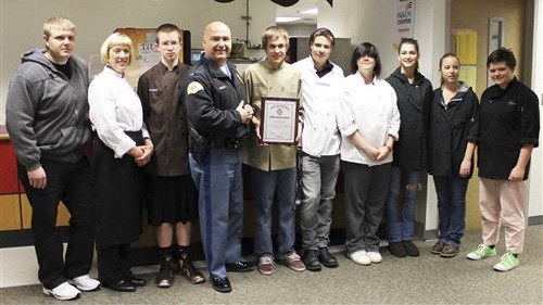 Lt. Daniel Atchison presents Mount Si Culinary Arts students with the State Fire Marshall’s Commendation Award
