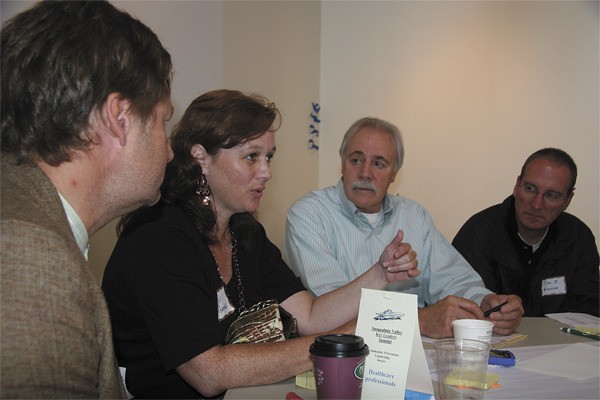 Kim Thomas talks about sharing problem-solving methods at the Key Leaders Summit. Listening are