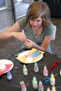 Teen artist Bina Yoker takes a critical look at her all-green creation. One of her skull's eyebrow turns up and one down