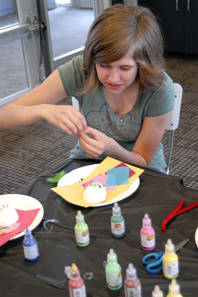 Teen artist Bina Yoker takes a critical look at her all-green creation. One of her skull's eyebrow turns up and one down