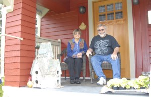 Kris and Dick Kirby relax on the porch of the house that they recently restored to its original 1914 look. Dick lived in the house as a teenager