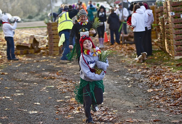 A young participant hauls a pineapple from the start line of the Winter Pineapple 5K