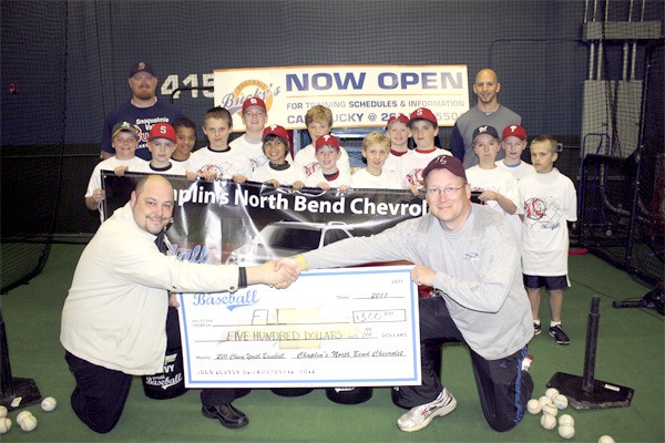 Chaplins North Bend Chevrolet Manager Mike Lawrence shakes hands with Falls Little League coach Brendon van Campen during a clinic with Bucky Jacobsen