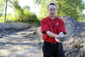 Letting silty soil run through his fingers