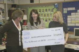 State Senator Cheryl Pflug (left) and Amgen spokeswoman Carol Pawlak (middle) present a $10