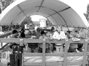 A group of parents and children head out to the field for a “farm school” activity at Jubilee Farm in Carnation. The farm provides farm school each pick-up day.