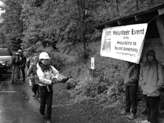 Volunteers carry poles and equipment on the Little Si Trail