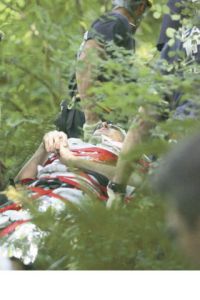 Rescuers carry a Sammamish teenager who was injured after jumping off of a rock into Tokul Creek on Monday