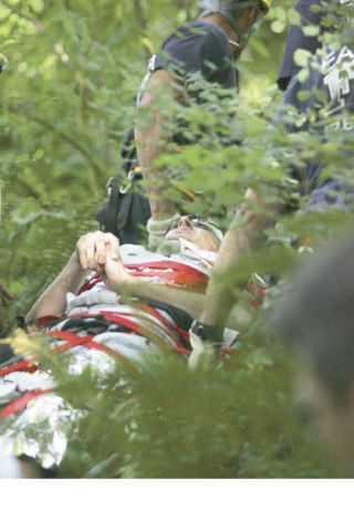 Rescuers carry a Sammamish teenager who was injured after jumping off of a rock into Tokul Creek on Monday