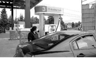 Charlie Fries of Kent fills up her tank at the newly opened Gateway Gas and Deli on Snoqualmie Ridge. Fries said the new station is convenient and was happy with the way the new station blends in with the neighborhood.