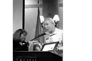 Paul Tredway accepts the business of the quarter award from Charlotte Jacobs