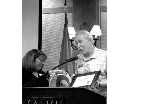 Paul Tredway accepts the business of the quarter award from Charlotte Jacobs