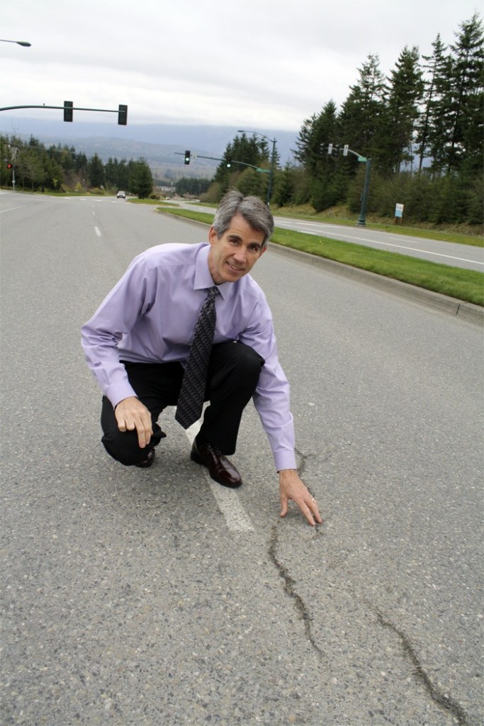 Snoqualmie Mayor Matt Larson examines cracks in the Snoqualmie Parkway. He’ll share an overview of the city on Friday.