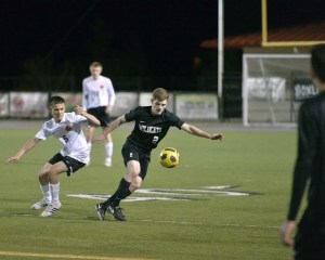 Reid Howland charges for the goal against Lewis & Clark High School March 18. A team captain