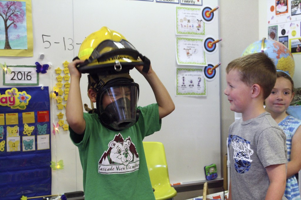Evan Pappas/Staff PhotoPhillip Hillhouse lets students try on his firefighter gear after the question and answer session.