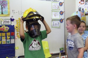 Evan Pappas/Staff PhotoPhillip Hillhouse lets students try on his firefighter gear after the question and answer session.
