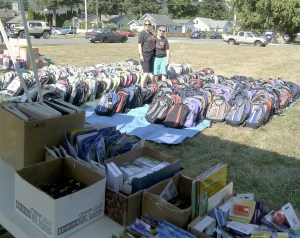 Courtesy PhotoVolunteers Joan Guenther and Jane Benson stand amidst the 300-plus backpacks distributed at last year’s annual school supply drive