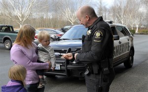 North Bend Chief and Sgt. Mark Toner offers badge stickers to Abel Wheeler and his sister
