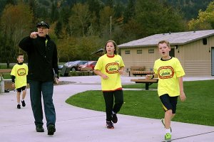 Coach Dutch Siedentopf directs the runners along the path at Tollgate Farm Park in North Bend.