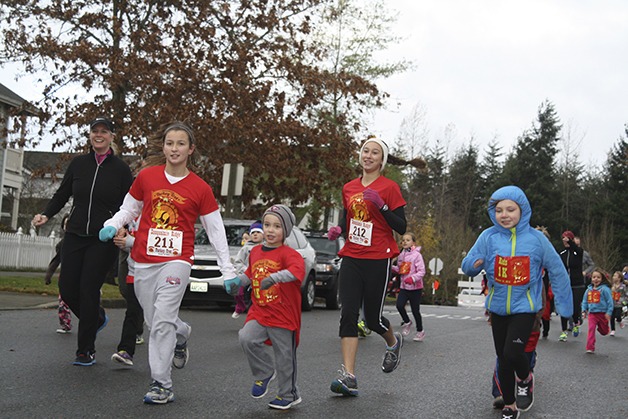 Snoqualmie sisters  Catalina and Miranda Jarocki keep pace with their five-year-old brother Marek in the children’s one-kilometer race