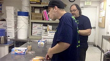 An employee of Twede’s Cafe tries a Twinkie in a mock-up of Kyle Twede’s planned cake-eating contest Saturday afternoon in front of the restaurant.
