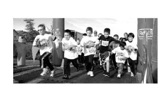 A quick pack of young runners charge forward in the opening moment of the children’s 1K race