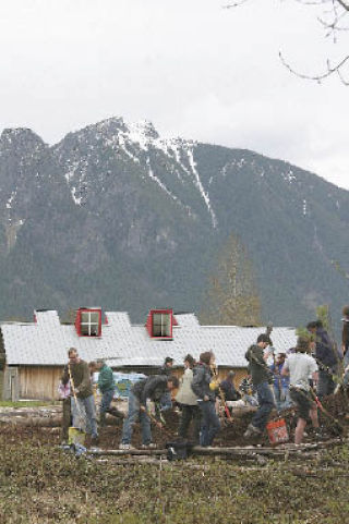 About 160 students and 20 teachers from The Bush School in Seattle hauled wood chips to build walking trails at Meadowbrook Farm on Tuesday