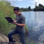 Josh Kubo from King County&rsquo;s Water and Land Resources Division downloading data from a thermistor by Oxbow Farm.