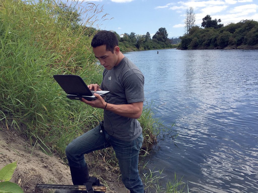 Josh Kubo from King County&rsquo;s Water and Land Resources Division downloading data from a thermistor by Oxbow Farm.