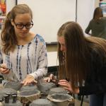 Cheerleaders Jenny McCall and Sammy Kremer work on the details of their bowl designs.