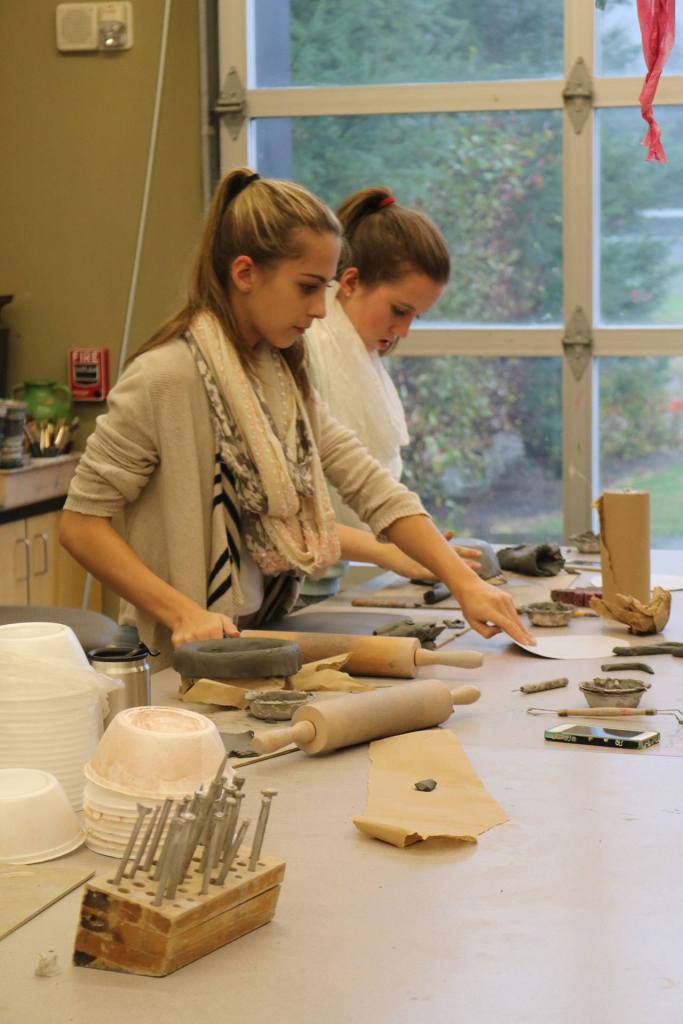 Evan Pappas/Staff Photo                                Elizabeth Ward and Taccoa Herman prepare their clay to be formed into a bowl shape.