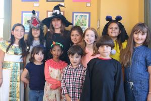 Snoqualmie Smart with Art students, dressed in their Halloween costumes, pose with their teacher at the Snoqualmie Valley Chamber of Commerce building. Front-row from left: Maria Castle, Vendanshi Rahul, Albert Brown and John David Castle. Back-row from left: Bella Vernon, Franchesca Tamburini, Smart with Art Teacher Kori Mankowski, Cynthia Castle, Eva Davison, Hailey Mays and Evelyn Brown. (Evan Pappas/Staff Photo)