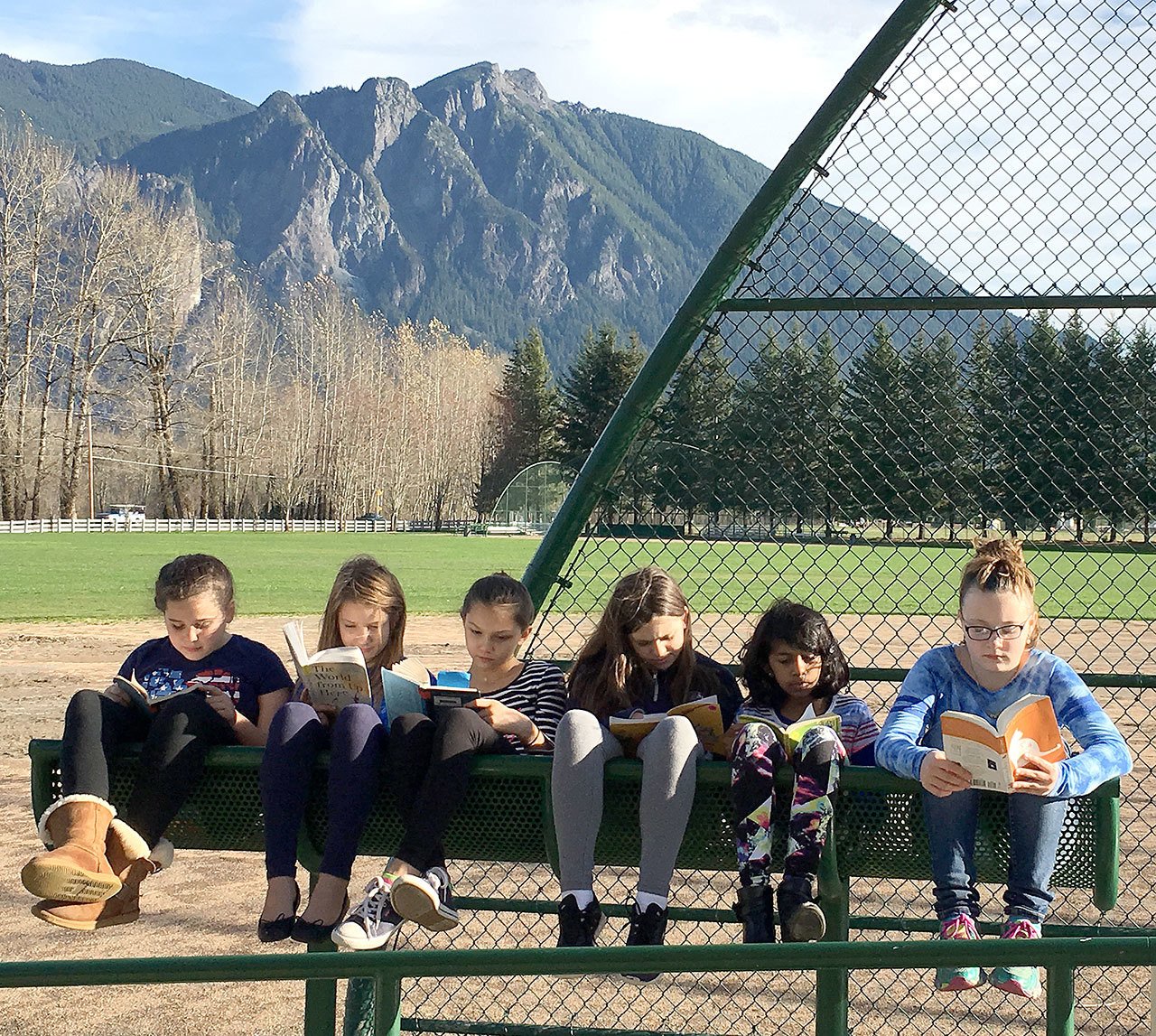 Curled up in the sunshine with their books are, from left, Elizabeth Conlon, Mallory Osborne, Taylor McCarthy, Kelsey Lingo, Taneesha Sharmin and Paige Horner, all students in Heidi Smith&rsquo;s class who spent part of Thursday reading outside.