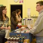 A food bank volunteer answers questions as a guest goes through the experience of shopping as a food bank client.                                Carol Ladwig/Staff Photo