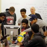 Students in the Siber Defense Club crowd around a computer to discuss how to solve a problem. (Courtesy Photo)