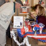 Rotary volunteer Louisa Harm, right, checks in Fred and Mary Blair, new to the Carnation community, for breakfast on Veterans Day.