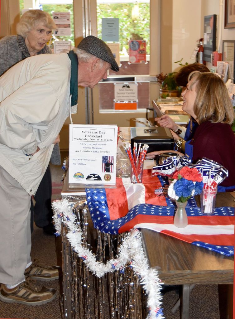 Rotary volunteer Louisa Harm, right, checks in Fred and Mary Blair, new to the Carnation community, for breakfast on Veterans Day.