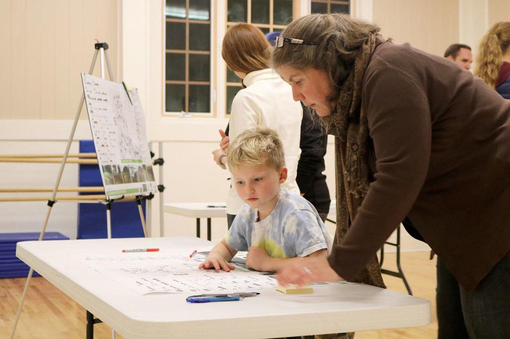 Susan Kingsbury-Comeau shows her son Damien the design plans for the new bike park. (Evan Pappas/Staff Photo)