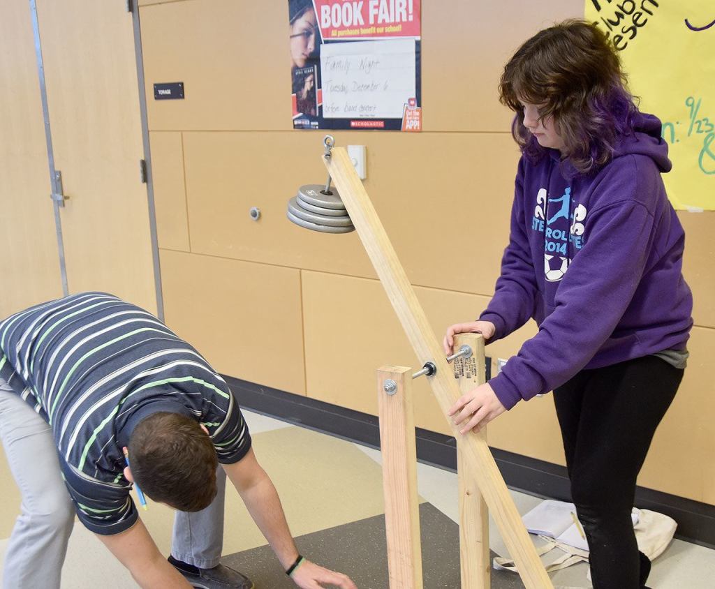 Teacher Kyle Wallace hels student Lauren Sherrill set up her catapult for a test.                                Carol Ladwig/Staff Photo