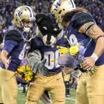 Cameron Van Winkle (left), Harry the Husky and Psalm Wooching meet at midfield before Saturday&rsquo;s game at Husky Stadium during Senior Day festivities.                                James Gibowski Photo
