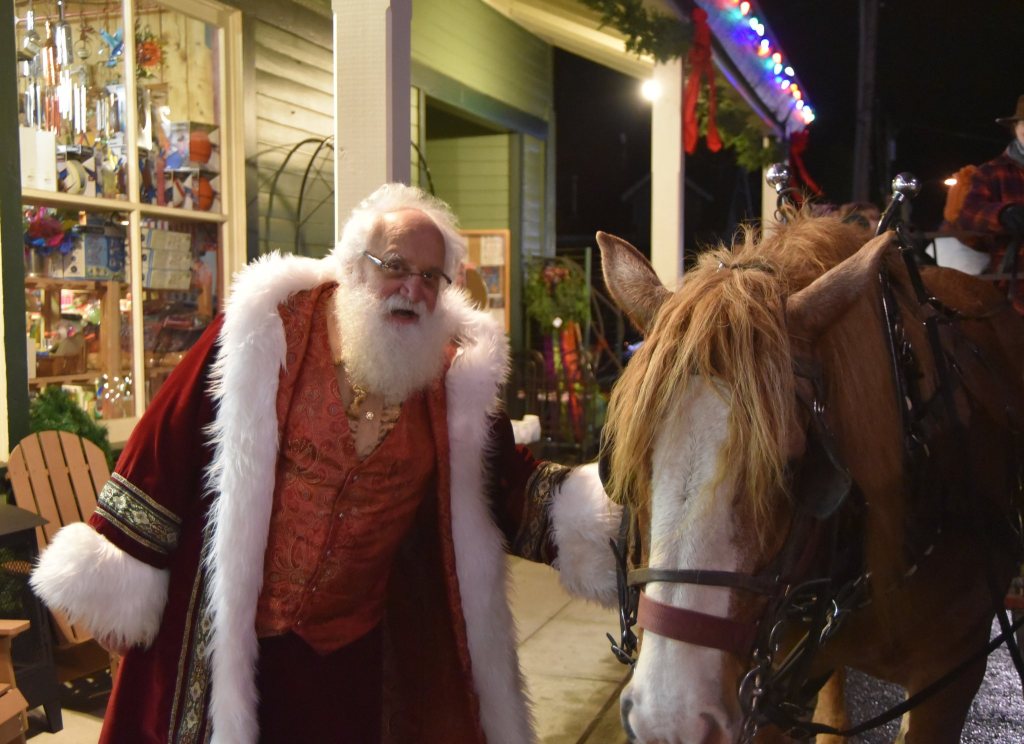Father Christmas greets one of the hard-working draft horses who pulled wagonloads of visitors through downtown Snoqualmie for hours Saturday during the city&rsquo;s holiday festivities.