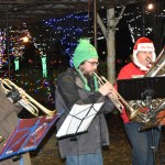 Sno Valley Winds musicians Erik Dickerson, center, and Erik Thurston performed for Saturday&rsquo;s tree lighting in Snoqualmie in holiday themed hats, the Grinch and Santa, respectively.