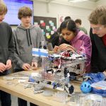 Hans Johnson, Davis Sauer, Shohini Ghosh and Peter Smith make small, last minute adjustments to their robot at the club meeting on Thursday, Dec. 8. (Evan Pappas/Staff Photo)