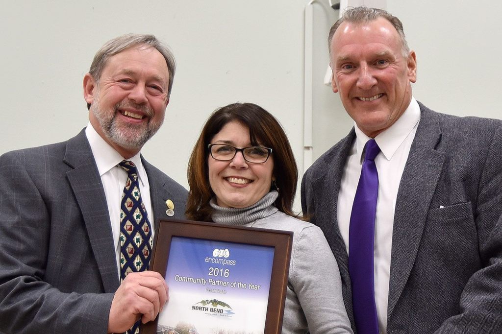 Encompass Executive Director Nela Cumming, center, presented North Bend Mayor Ken Hearing and Councilman and Mayor Pro-tem Ross Loudenback with the Community Partner of the Year award Dec. 6.                                Carol Ladwig/Staff Photo